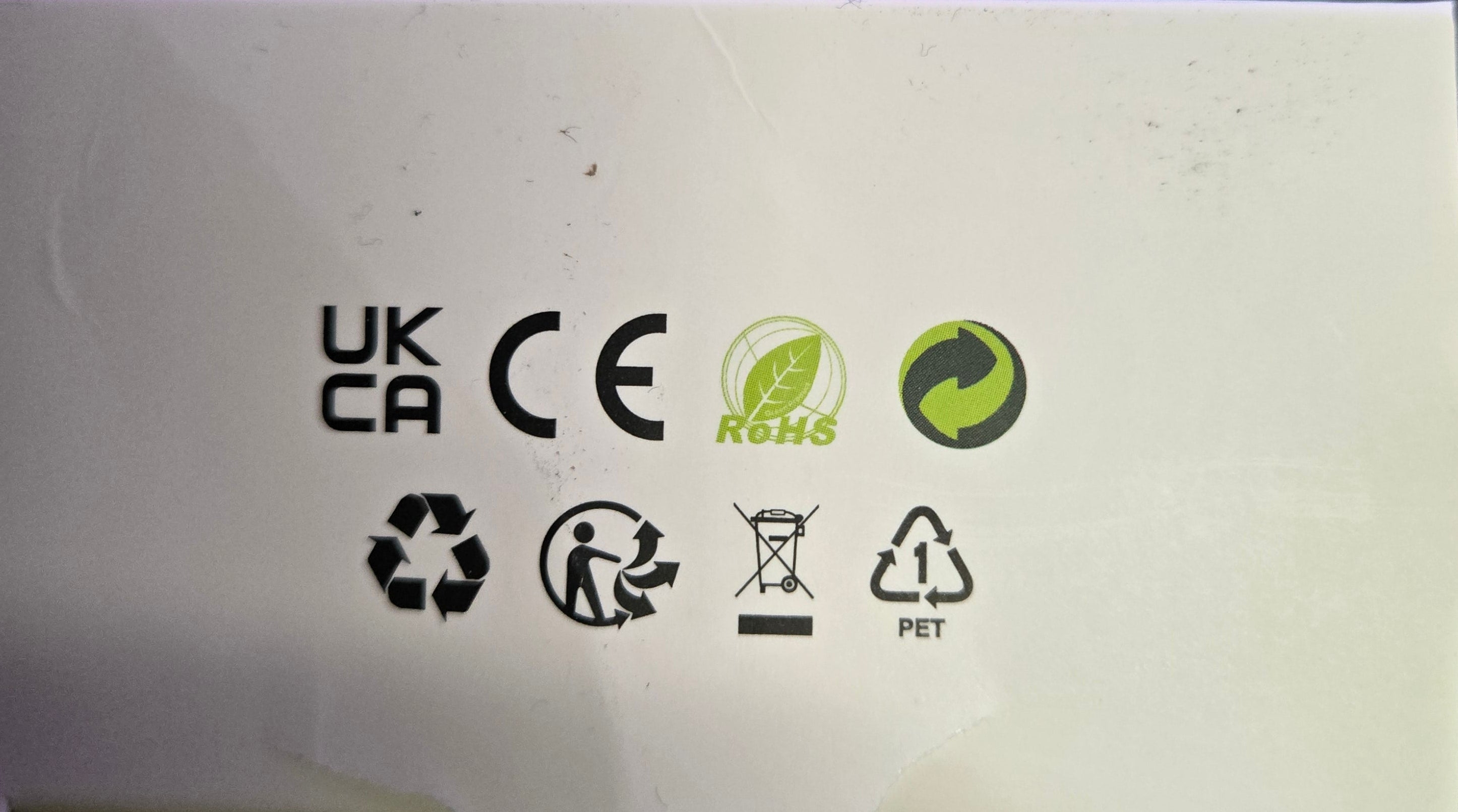 Close-up of a white electronic device with various symbols on it, blurred background