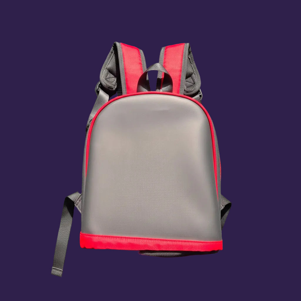 A red and gray padded shoulder bag or harness-style pouch with gray straps, shown laid flat on a textured green surface.