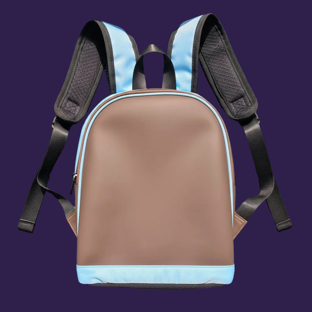 A light blue and dark brown padded backpack or travel bag with black straps, laid flat on a ribbed green surface.