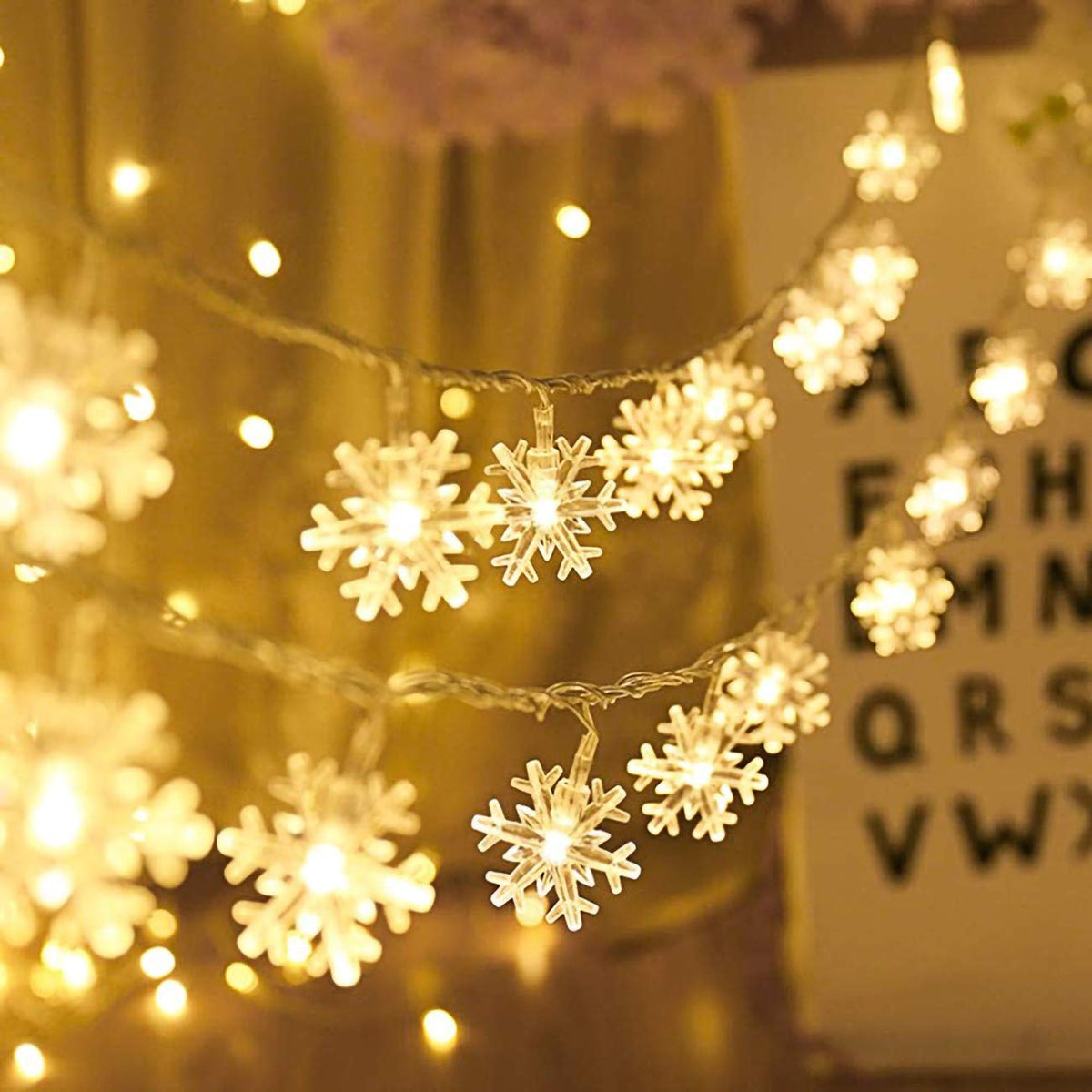 Warm white LED snowflake fairy lights glowing on draped strand