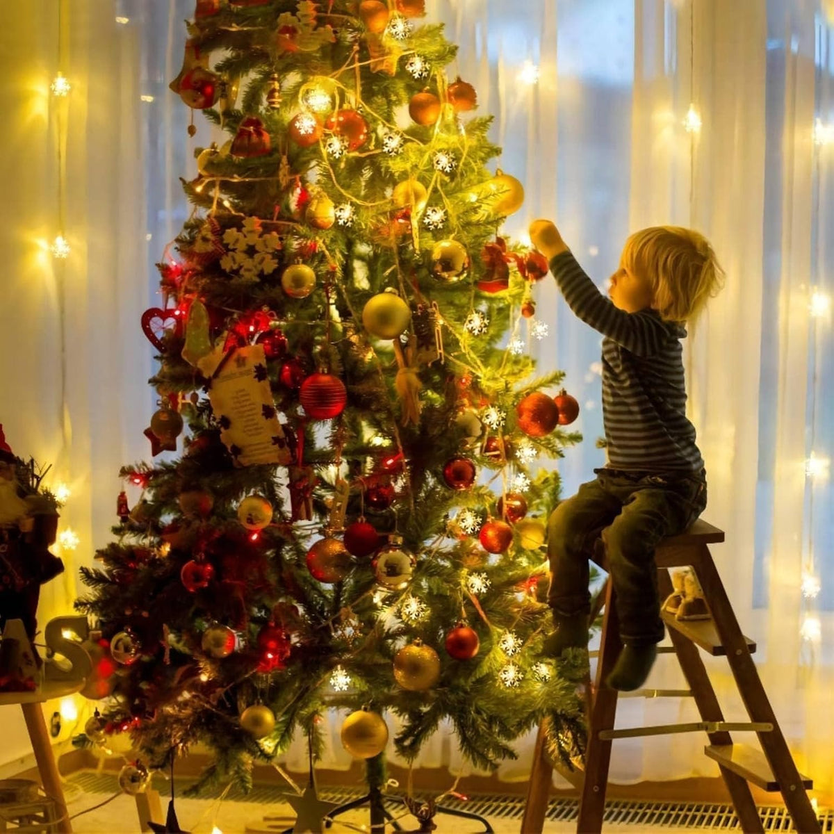 Snowflake fairy lights decorating indoor Christmas tree with ornaments