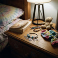 KPOP charm bracelet with blue beads, treble clef, and owl charms styled on a wooden nightstand