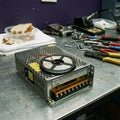 City Store S-250-12 250W 12V DC Power Supply Unit on a workbench with LED strips
