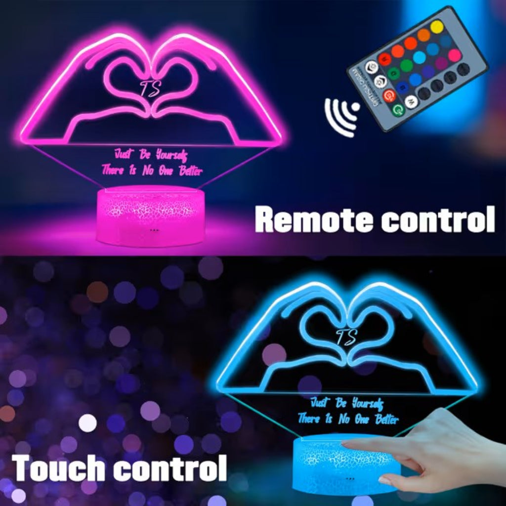 An LED acrylic heart-shaped night light with a cylindrical base, shown in two control modes: 'Remote control' at the top glowing pink, and 'Touch control' at the bottom glowing blue. A hand is shown touching the base in the lower section.