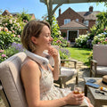 Woman wearing a white Bladeless Neck Cooler outdoors