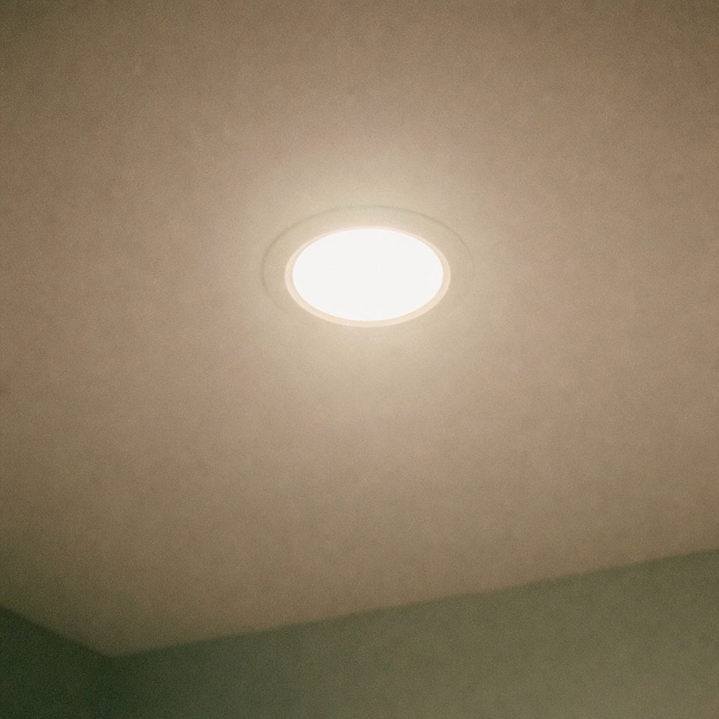 11W Round LED Recessed Ceiling Downlight installed in matte ceiling, glowing warm light