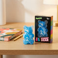 Squishy Gummy Bear toy placed on a clean wooden desk next to a colorful notebook