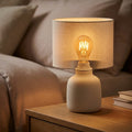 B22 Amber Vintage LED Bulb illuminated in a cozy bedside lamp setup
